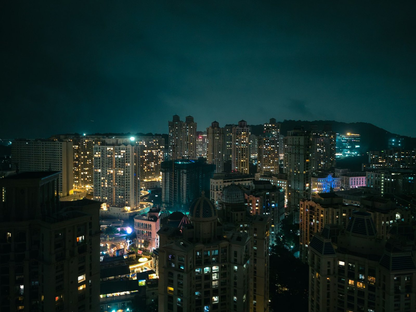 夜深時分，高樓屋苑外牆窗戶燈火通明的街景示意（非個別公司工程相）